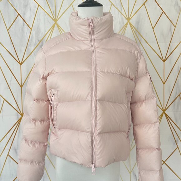 This Moncler pink down jacket features a mini-puffy design offering warmth and